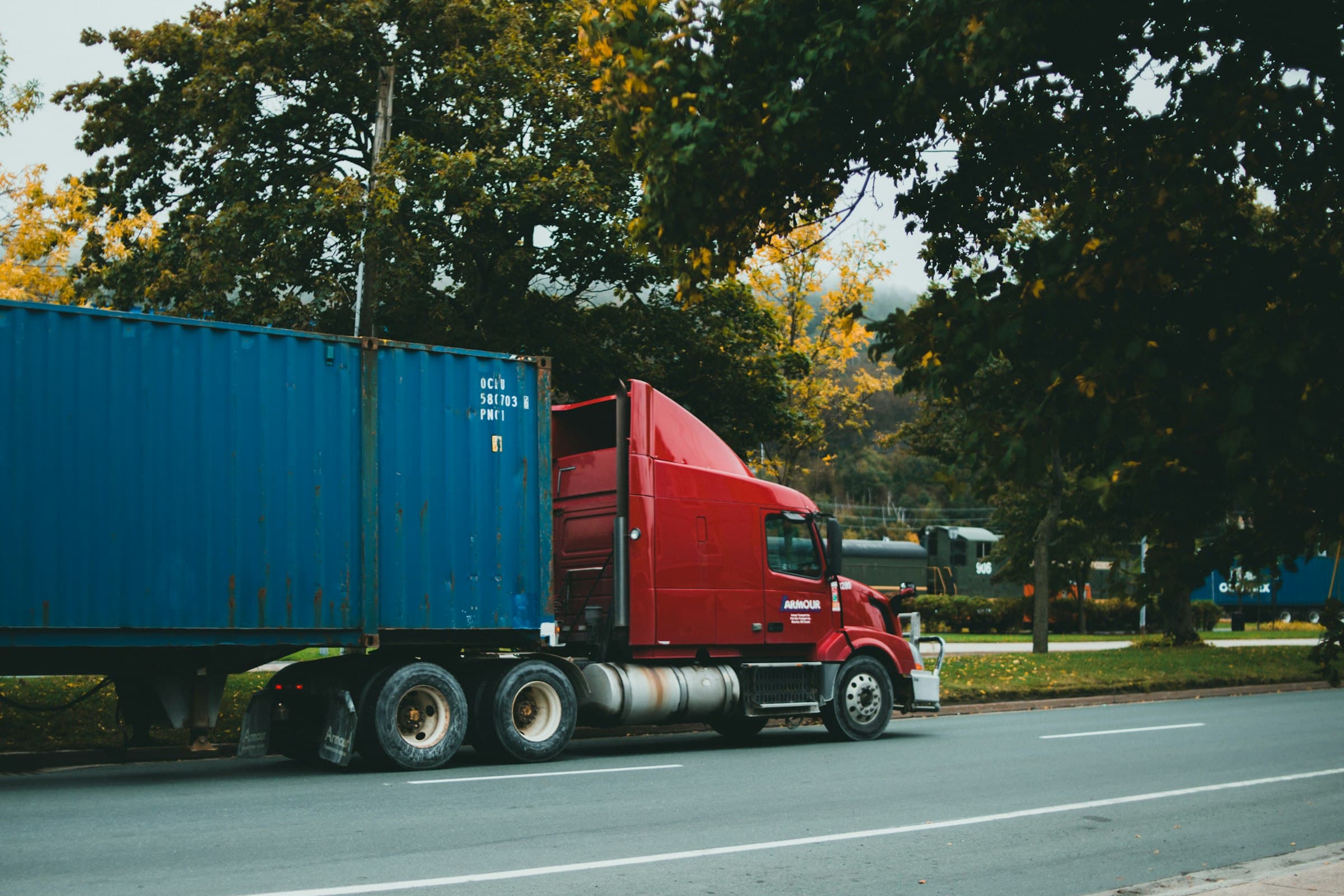 A blue shipping container on a red semi truck